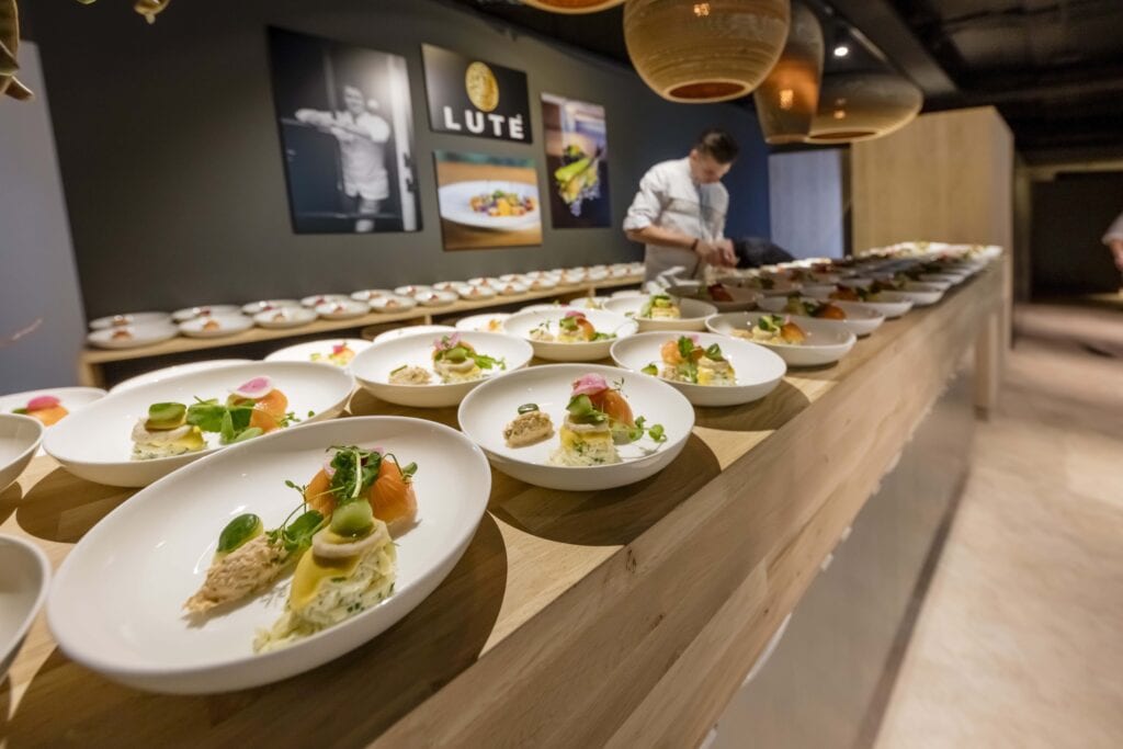 Een kok die een gerecht voor veel mensen aan het afmaken is